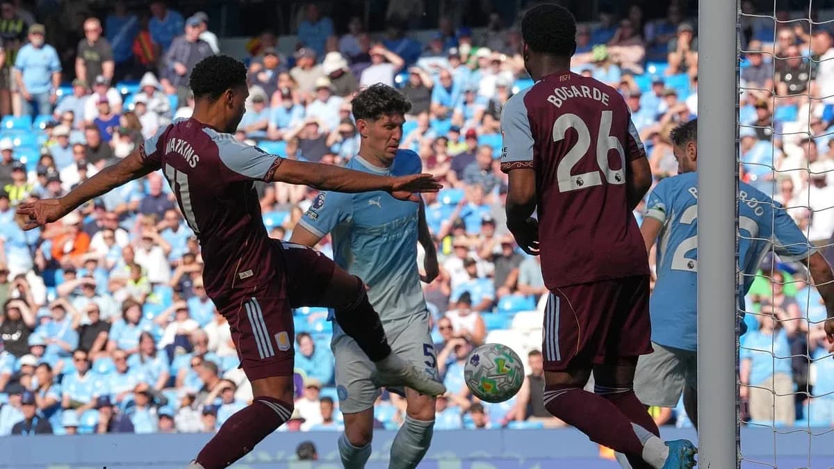 Jugador de Aston Villa defendiendo un tiro de Manchester City Jugador de Aston Villa defendiendo un tiro de Manchester City