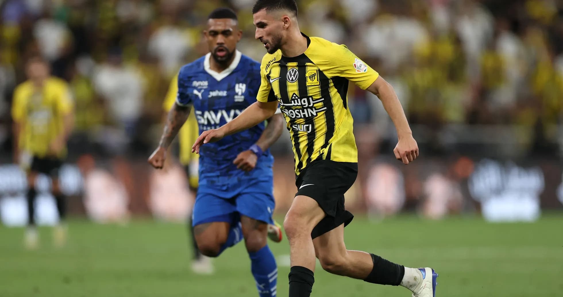 Jugador de Al Ittihad driblando ante defensor rival Jugador de Al Ittihad driblando ante defensor rival