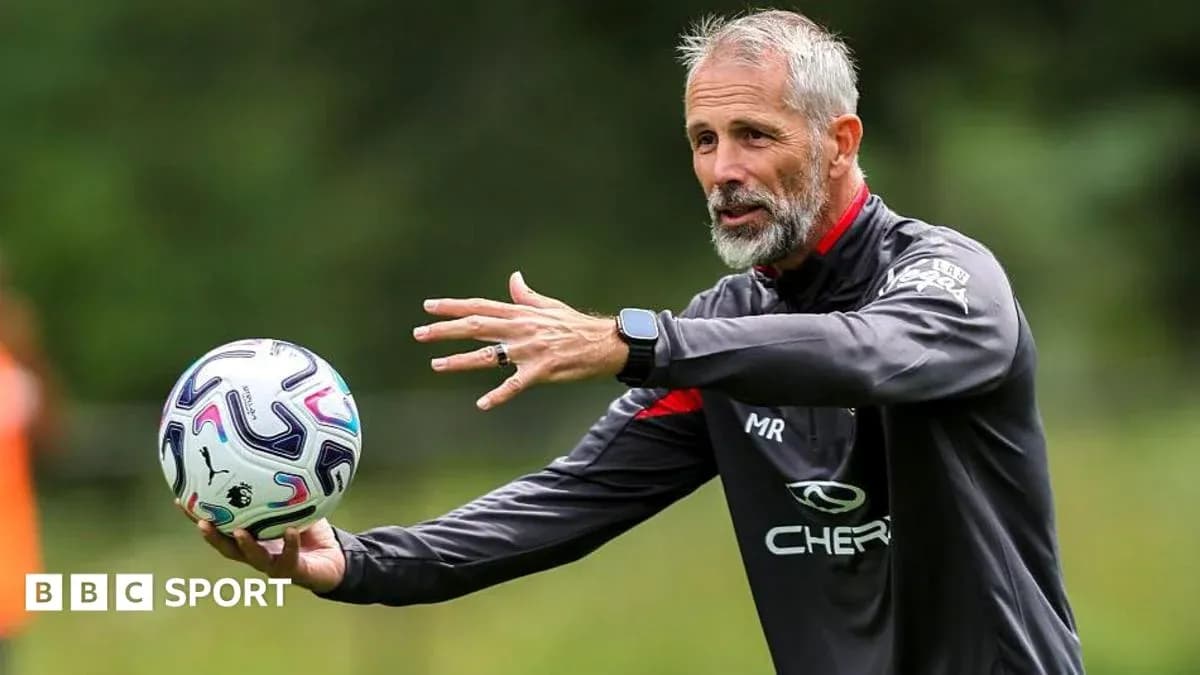 Entrenador explicando tácticas con balón en mano Entrenador explicando tácticas con balón en mano