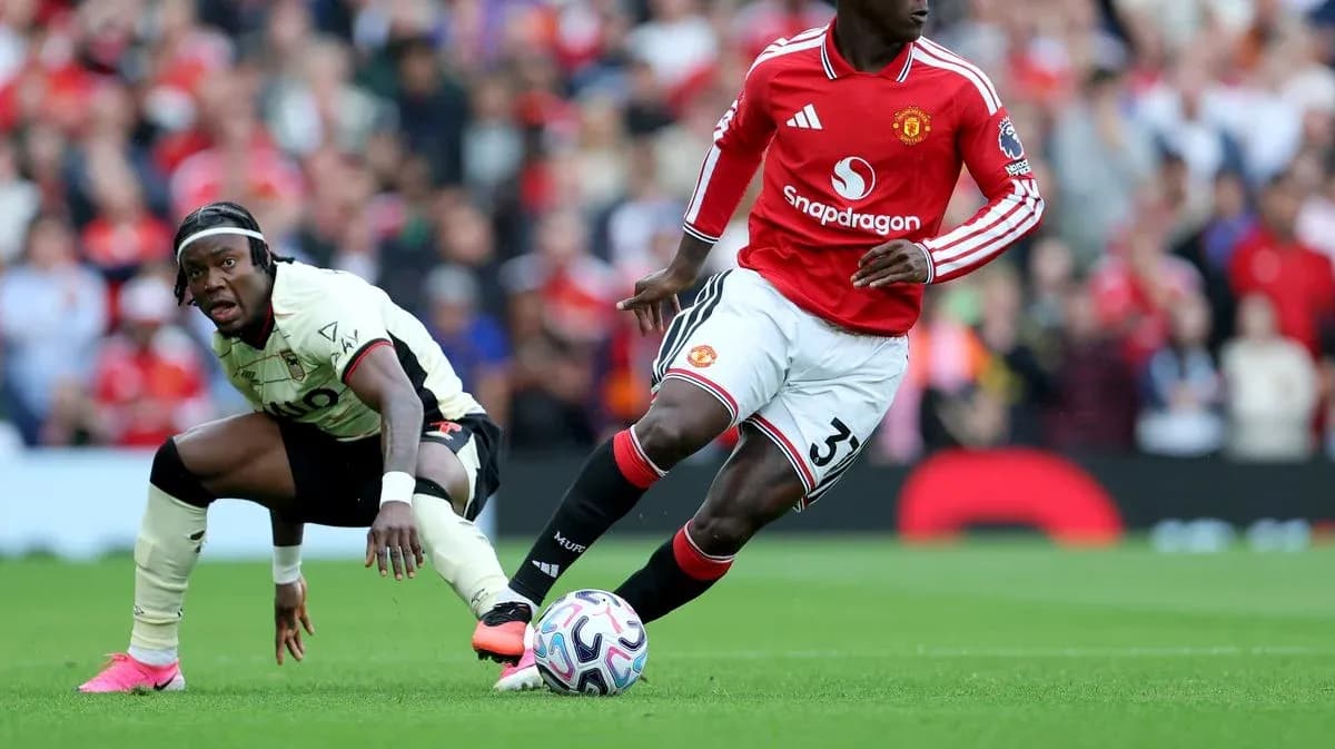 Jugador de Manchester United driblando balón en el campo Jugador de Manchester United driblando balón en el campo
