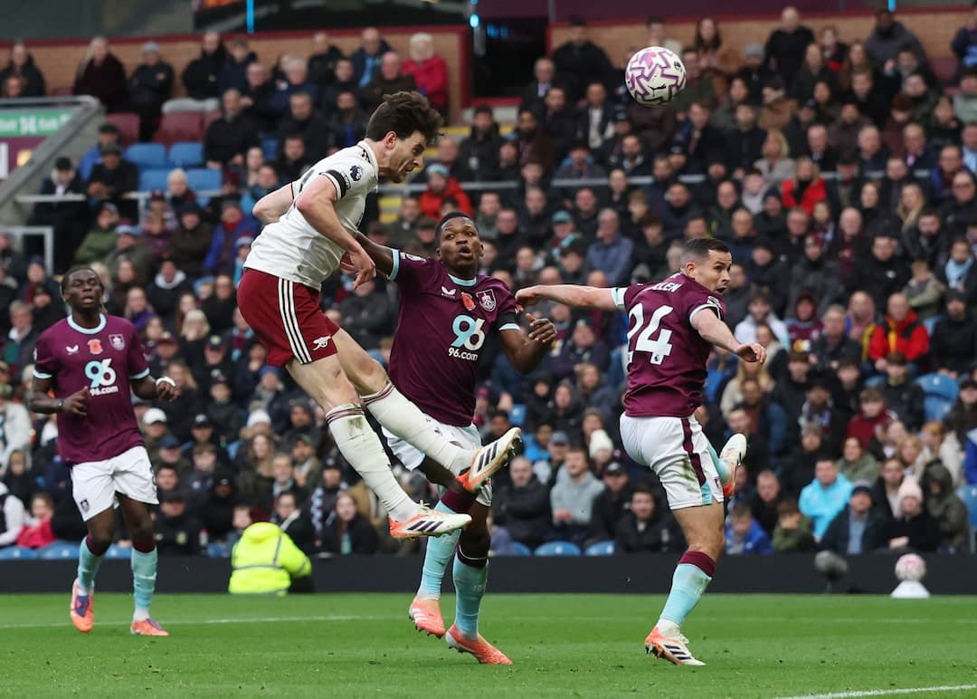Jugador de Arsenal saltando para cabecear Jugador de Arsenal saltando para cabecear