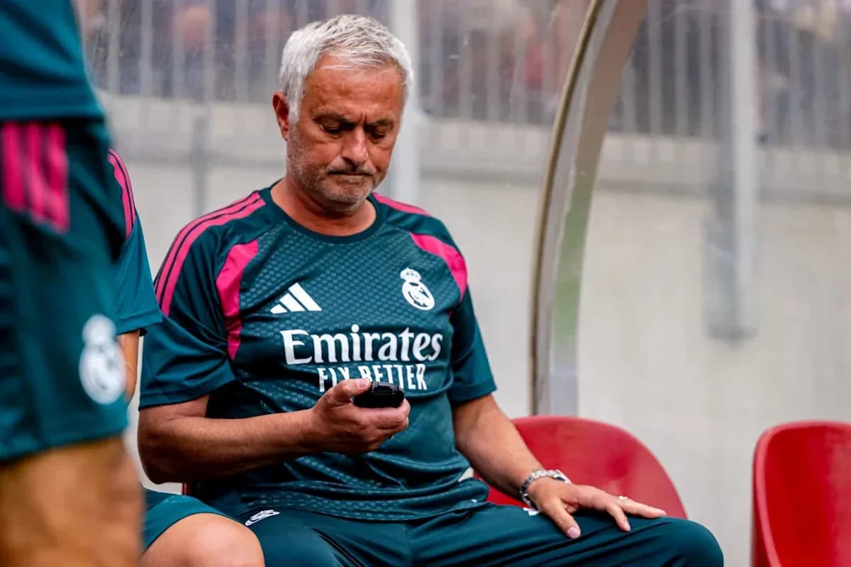 Entrenador de Real Madrid revisando su teléfono en el banquillo Entrenador de Real Madrid revisando su teléfono en el banquillo