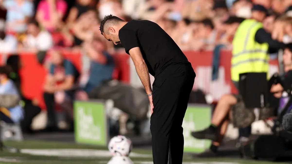 Entrenador mirando hacia abajo junto al balón Entrenador mirando hacia abajo junto al balón