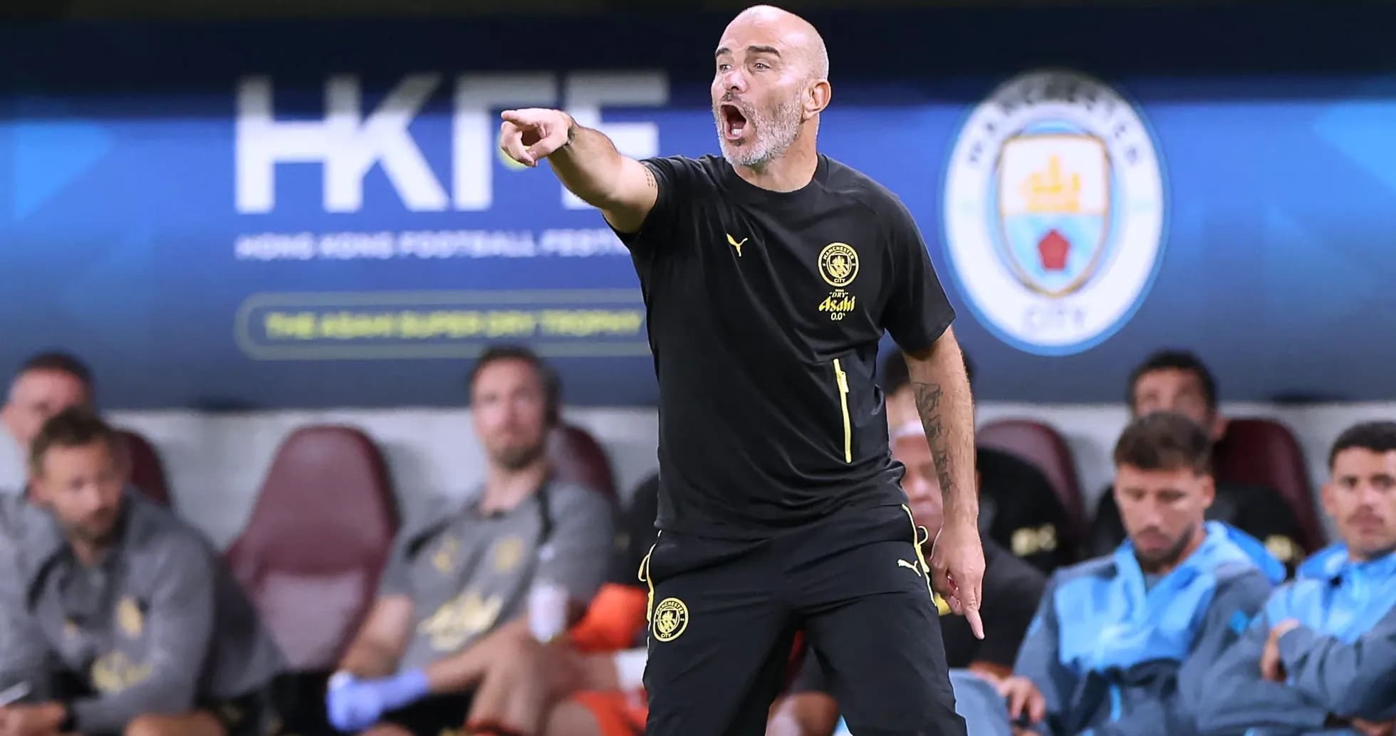 Entrenador dirigiendo desde el banquillo durante partido Entrenador dirigiendo desde el banquillo durante partido