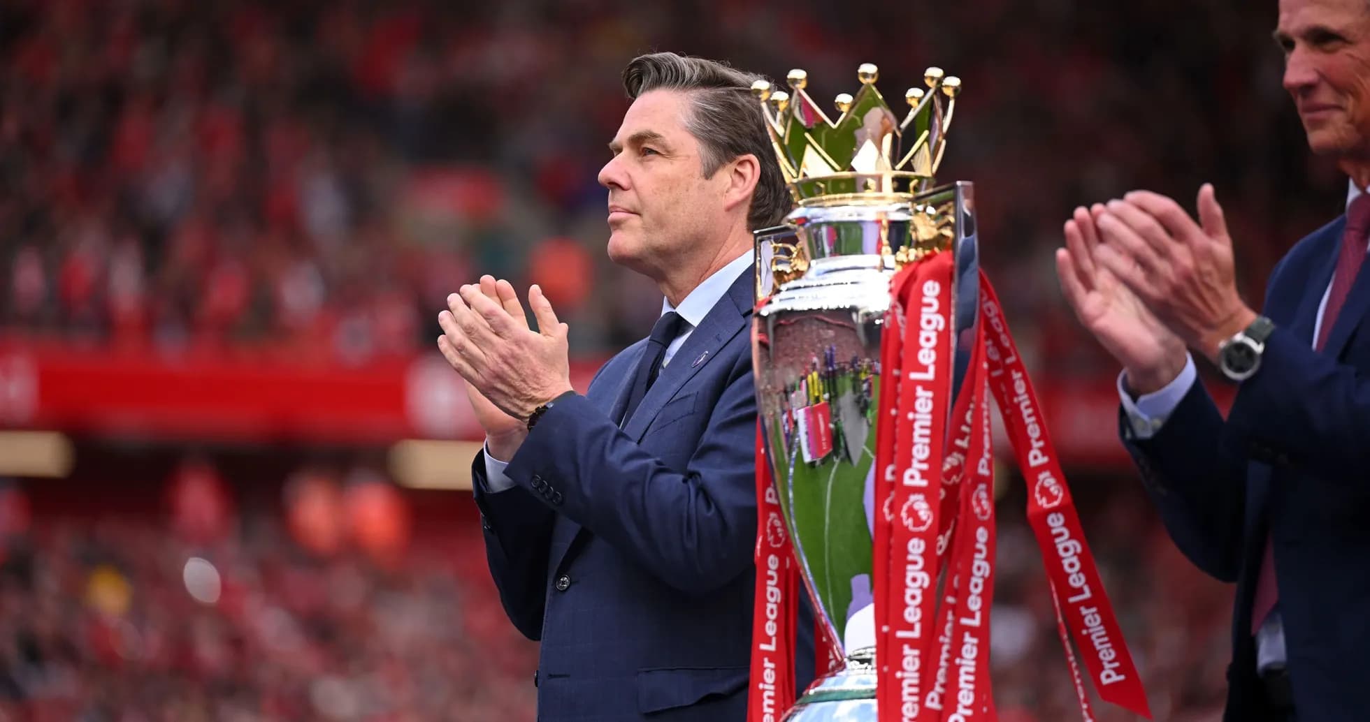 Hombre aplaudiendo junto al trofeo de la Premier League Hombre aplaudiendo junto al trofeo de la Premier League
