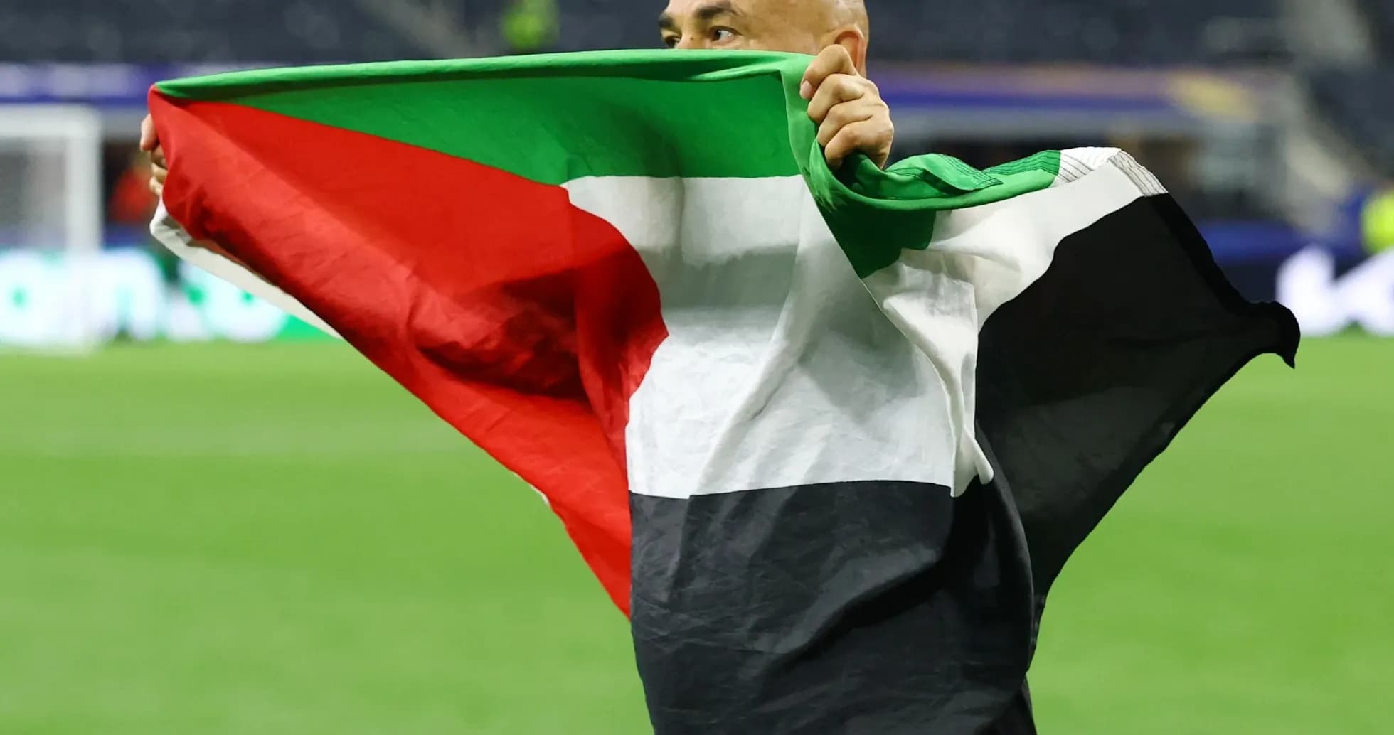Hombre sosteniendo una bandera durante un evento deportivo Hombre sosteniendo una bandera durante un evento deportivo