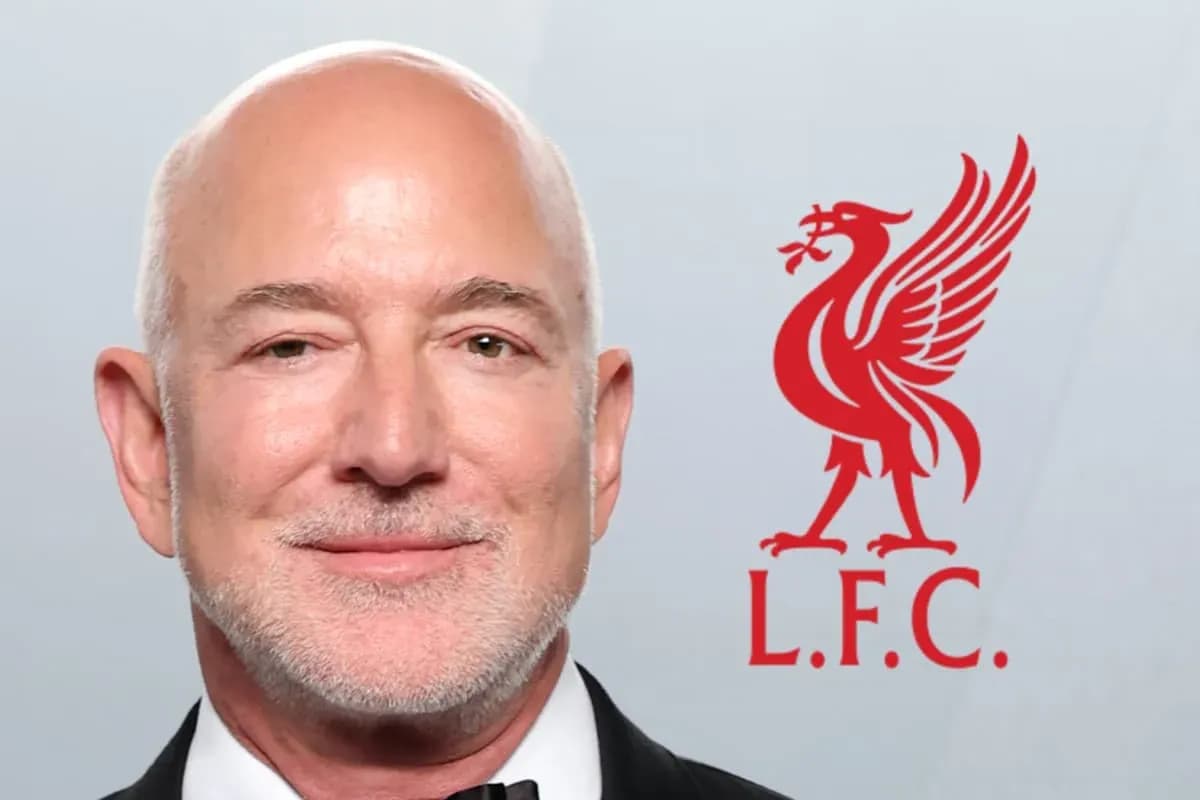 Hombre sonriendo con el logo de Liverpool detrás Hombre sonriendo con el logo de Liverpool detrás