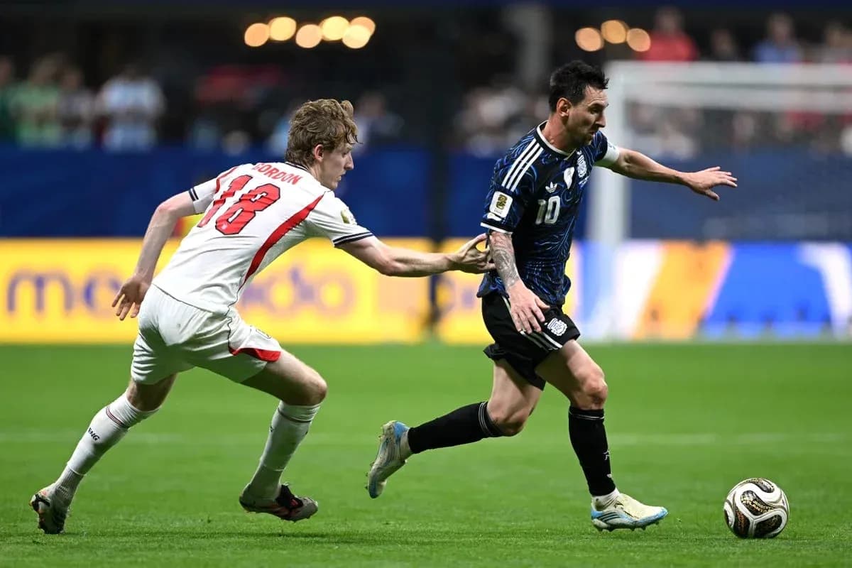 Jugador argentino driblando mientras es seguido por rival Jugador argentino driblando mientras es seguido por rival