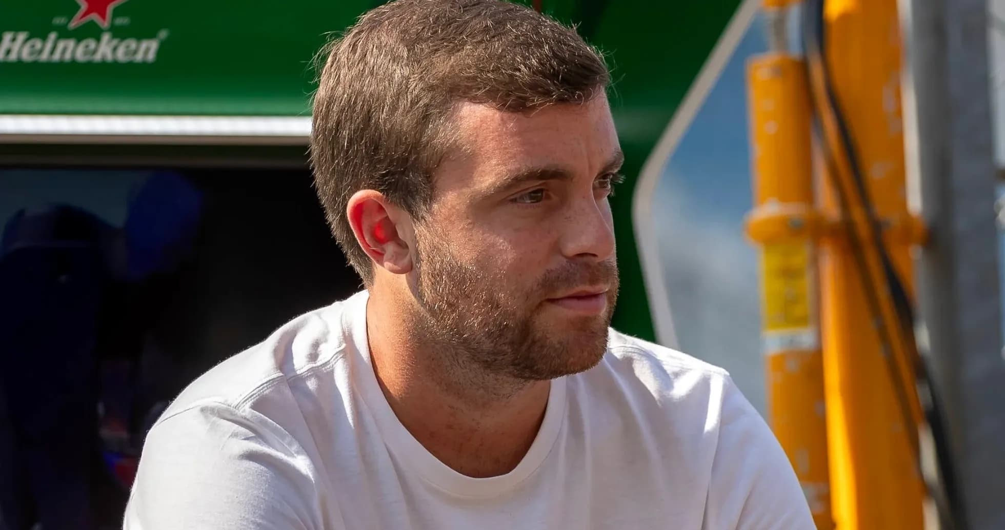 Hombre sentado con camiseta blanca en el paddock Hombre sentado con camiseta blanca en el paddock