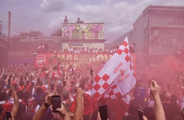 Aficionados de Arsenal celebrando con humo rosa Aficionados de Arsenal celebrando con humo rosa