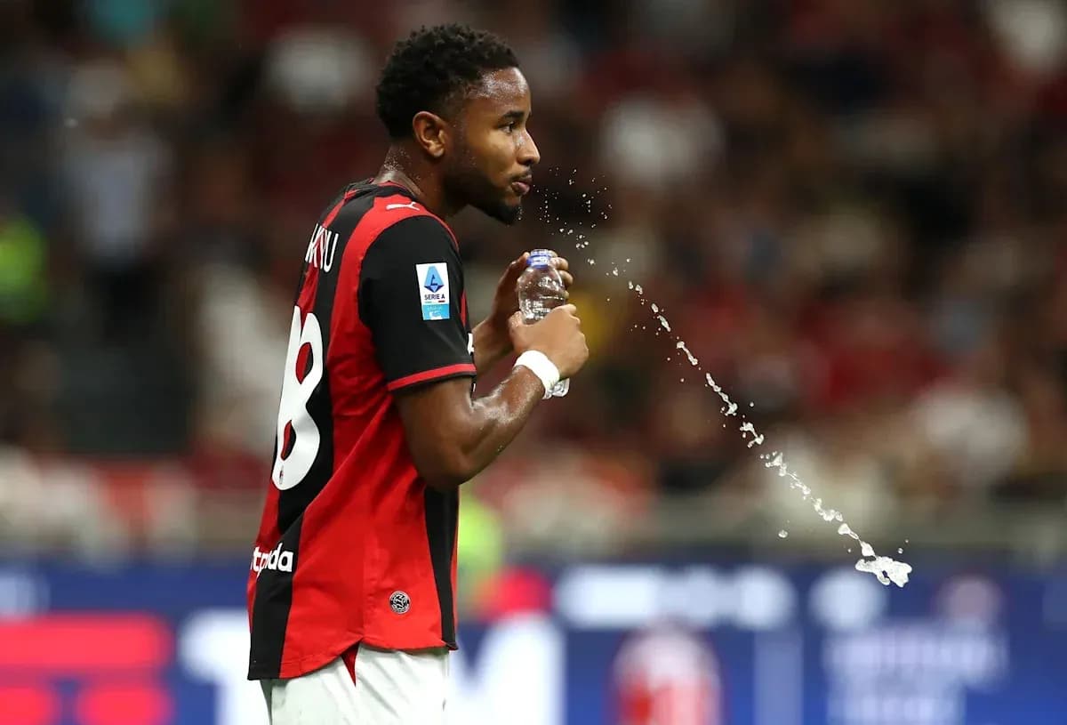 Jugador con camiseta negra y roja bebiendo agua Jugador con camiseta negra y roja bebiendo agua
