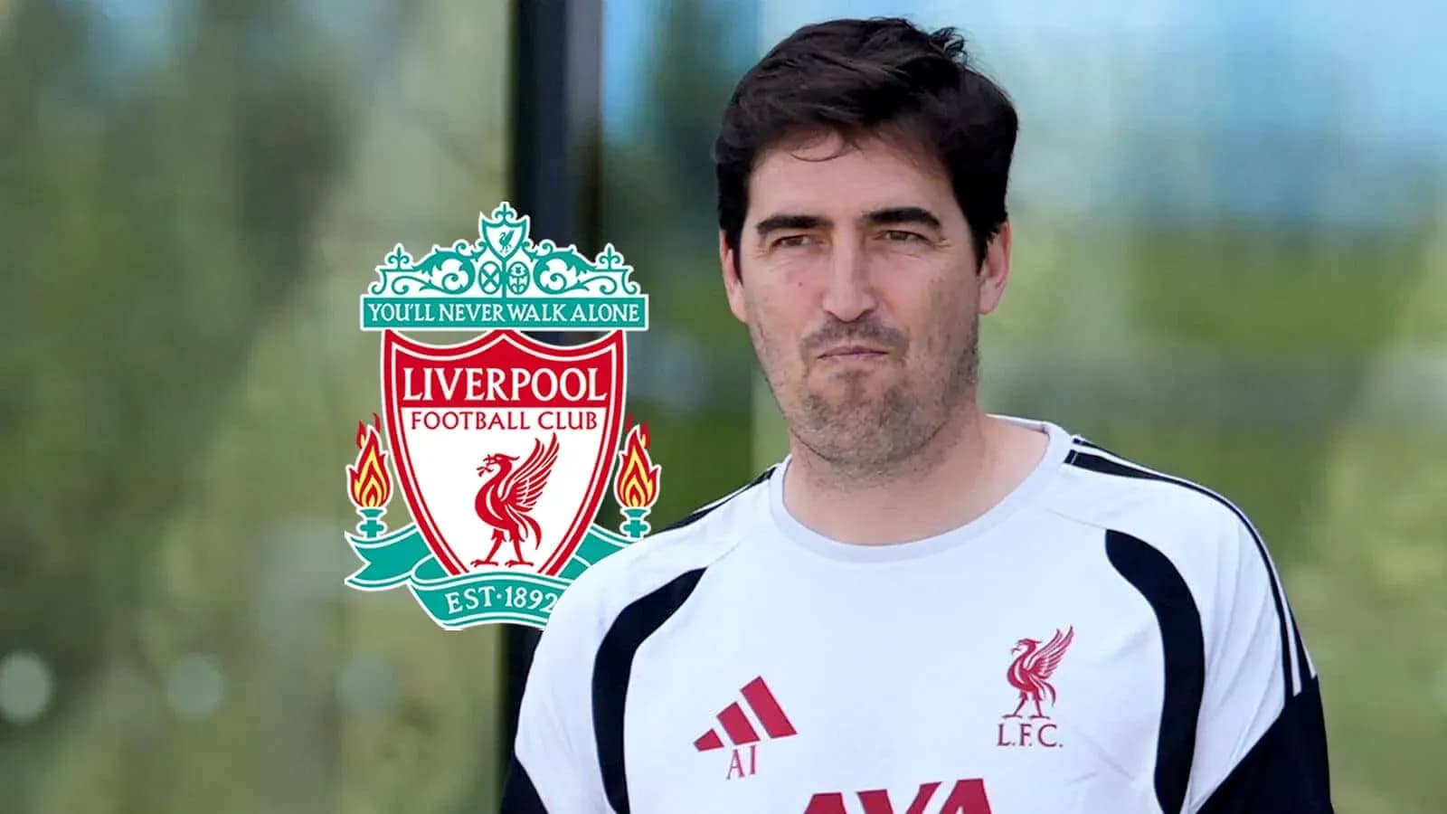 Entrenador de Liverpool posando junto al logo del club Entrenador de Liverpool posando junto al logo del club